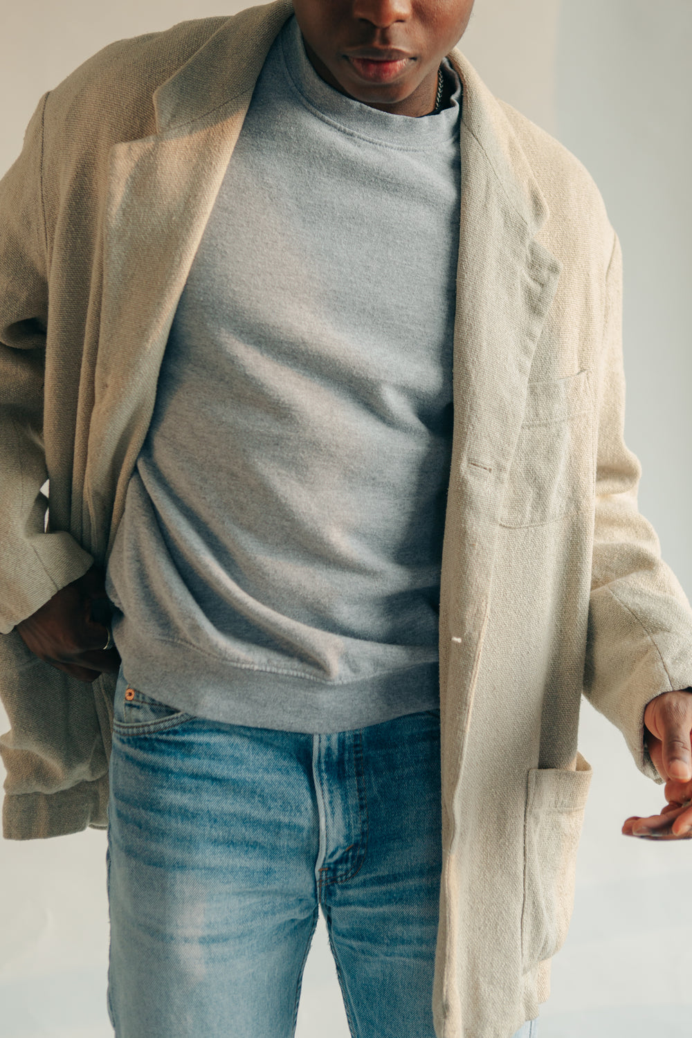 man-poses-in-light-colored-overcoat
